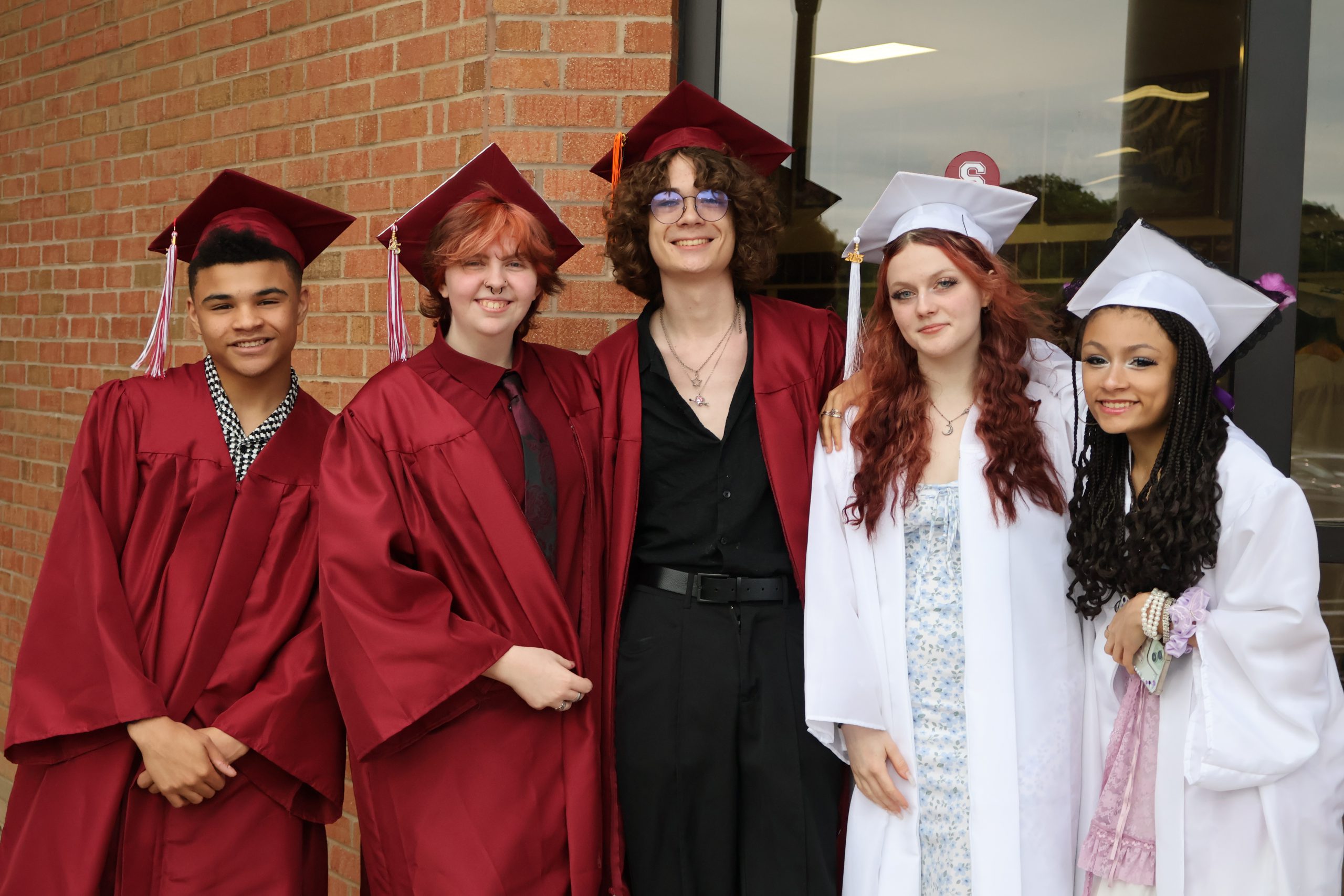 students standing together for photo after graduating