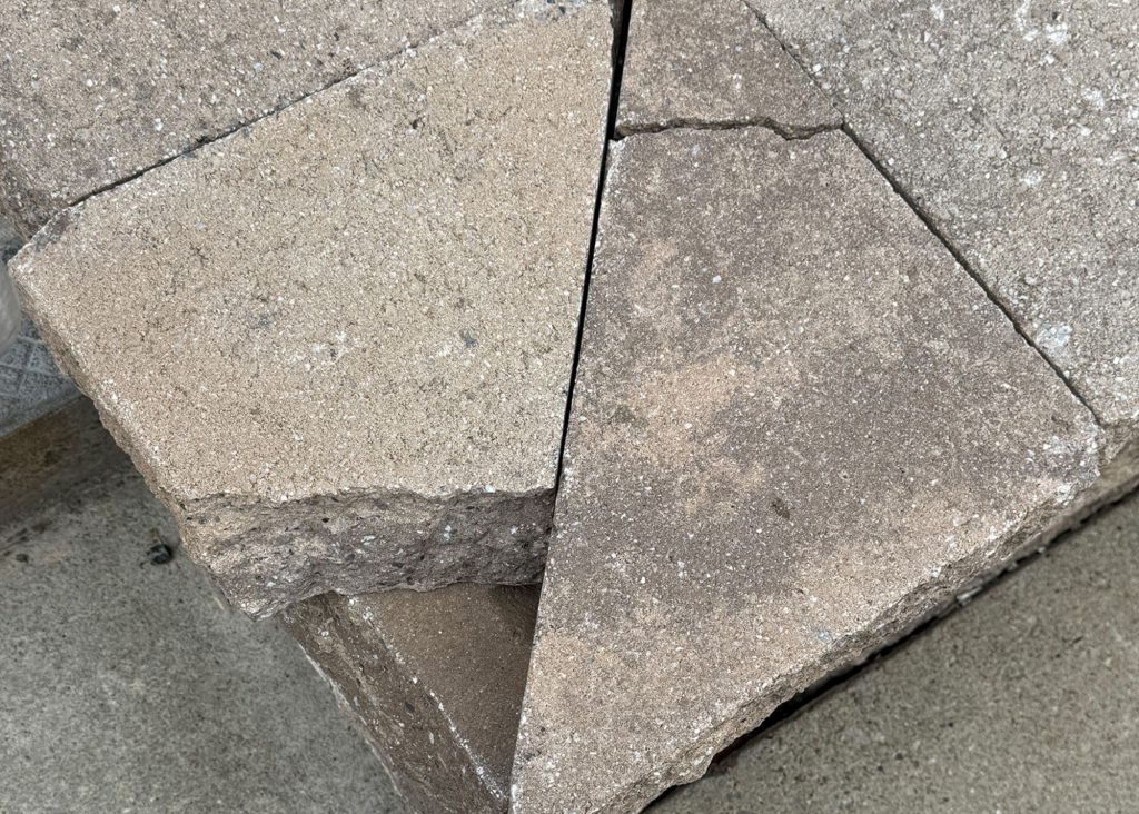 Cracked stonework on a school walkway outside.