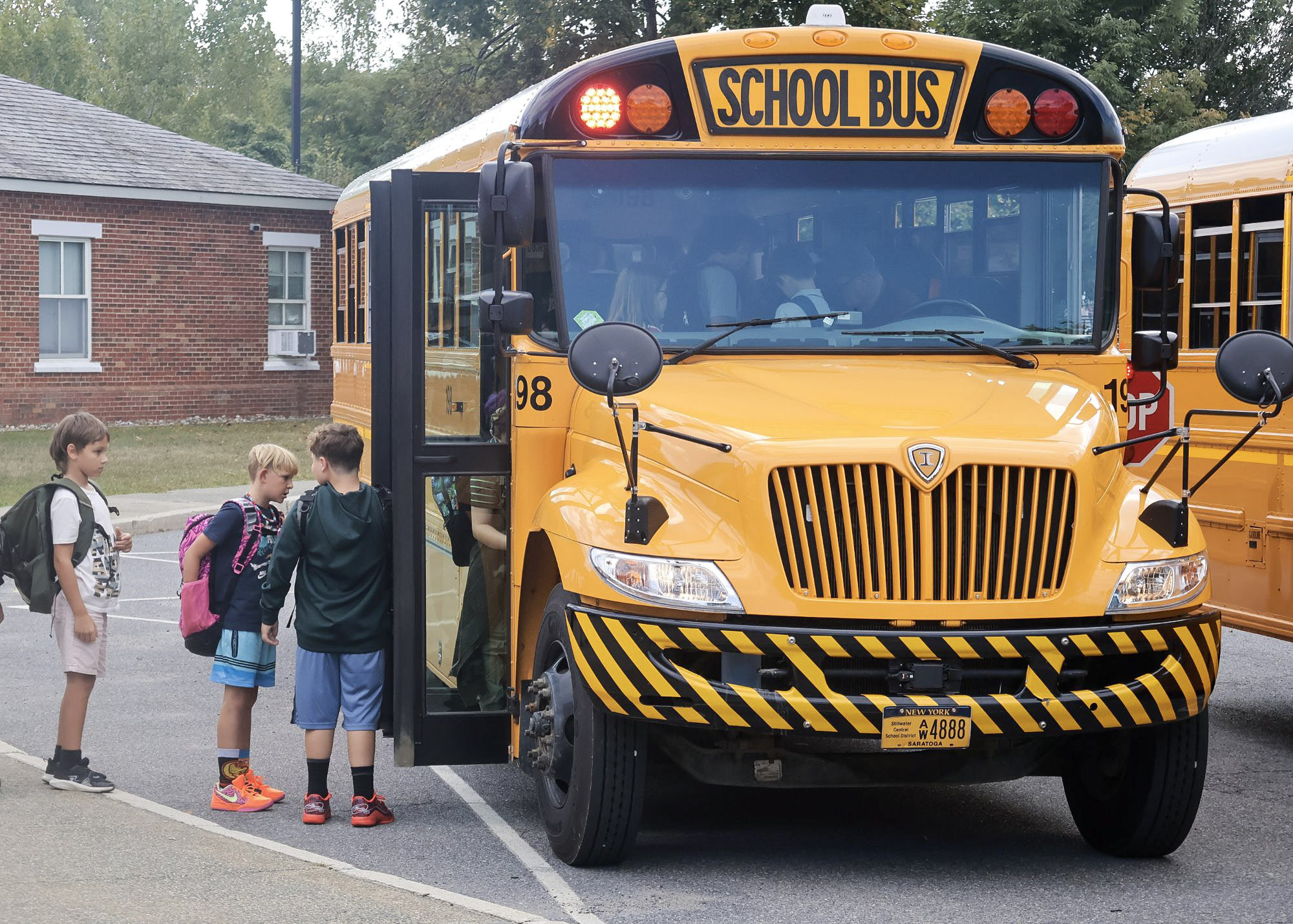 Elementary students boarding a school bus.