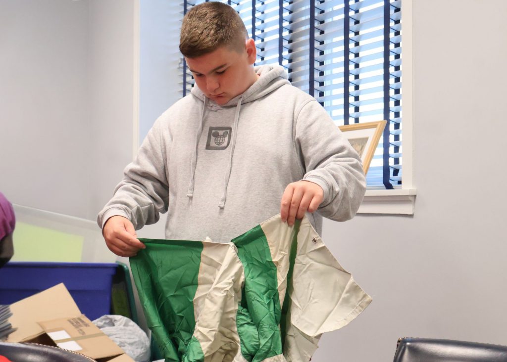 Student folding a jockey shirt.