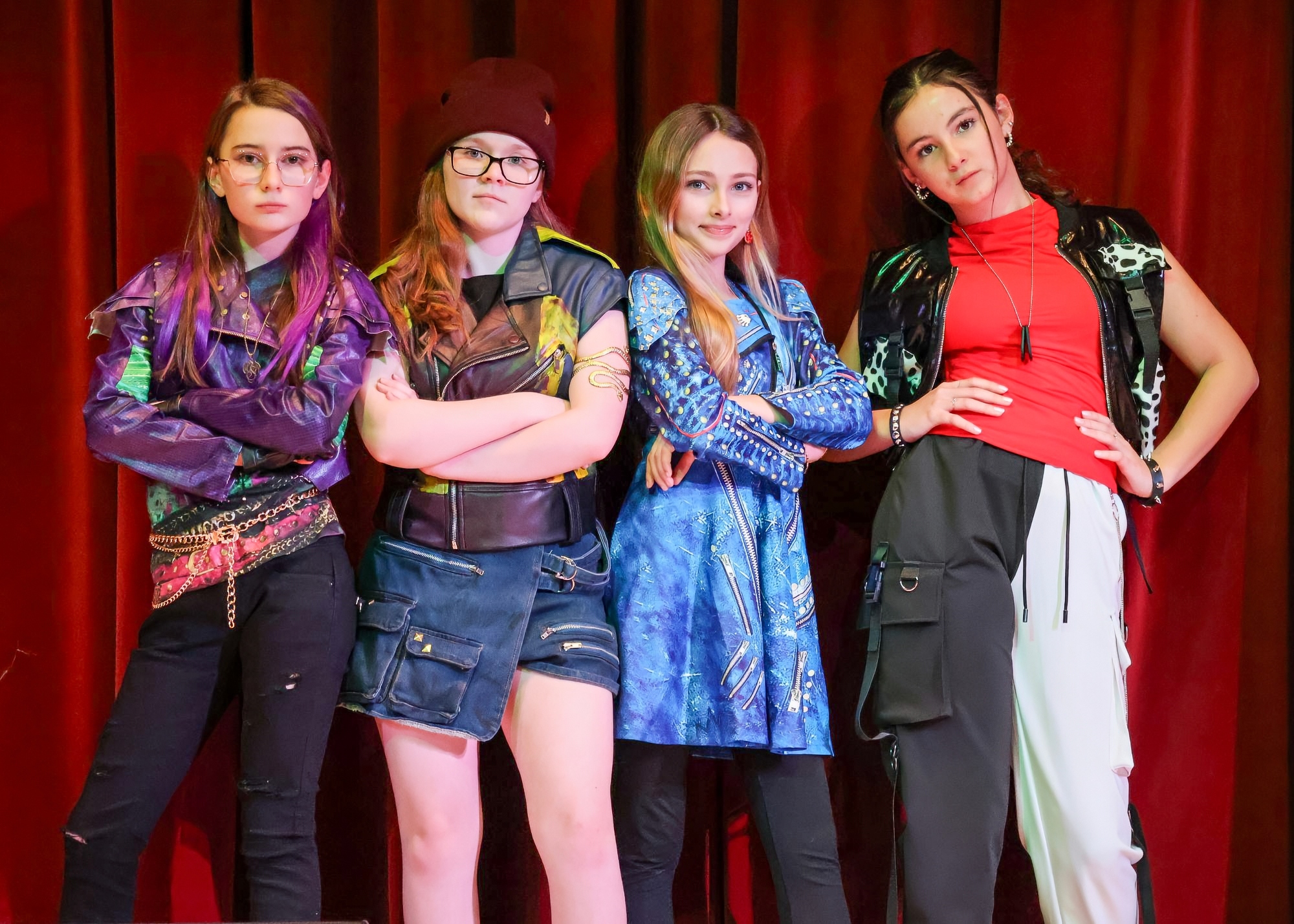 An adult engaging in a fist bump with a student huddled by more students.